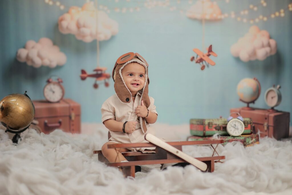 pexels photo 32627915 32627915 Adorable baby dressed as a pilot surrounded by adventure-themed decor in a whimsical indoor setting.
