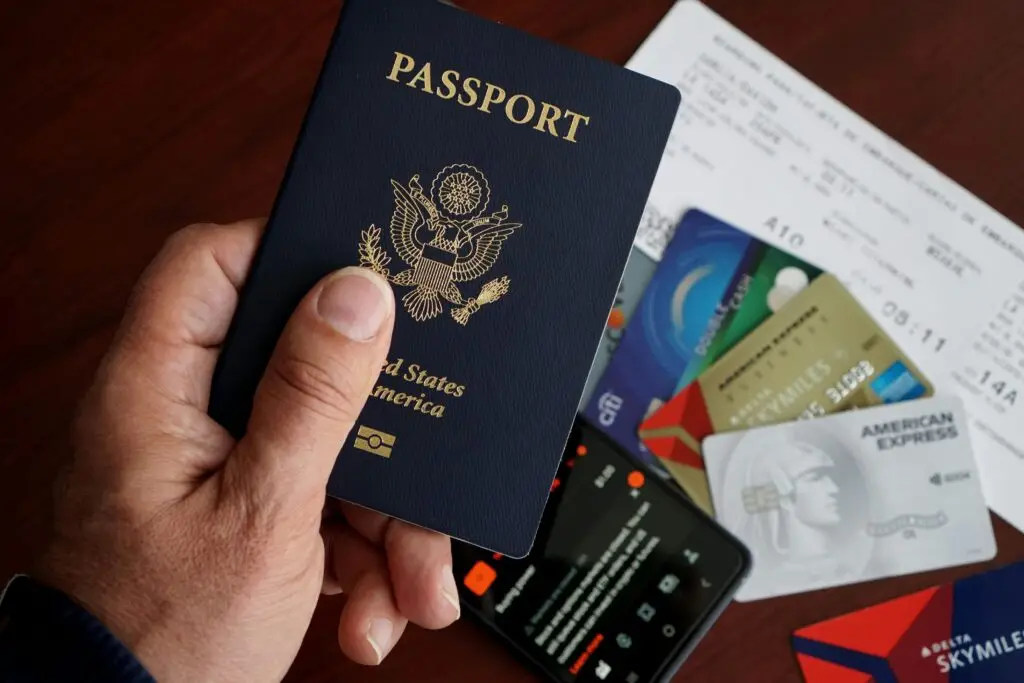 pexels photo 32642491 32642491 A close-up of a US passport with credit cards, tickets, and a mobile phone on a table.